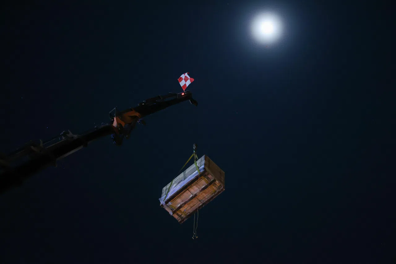 装有太阳能板的箱子高挂空中，与当晚的满月形成有趣的画面。（李冠卫摄）