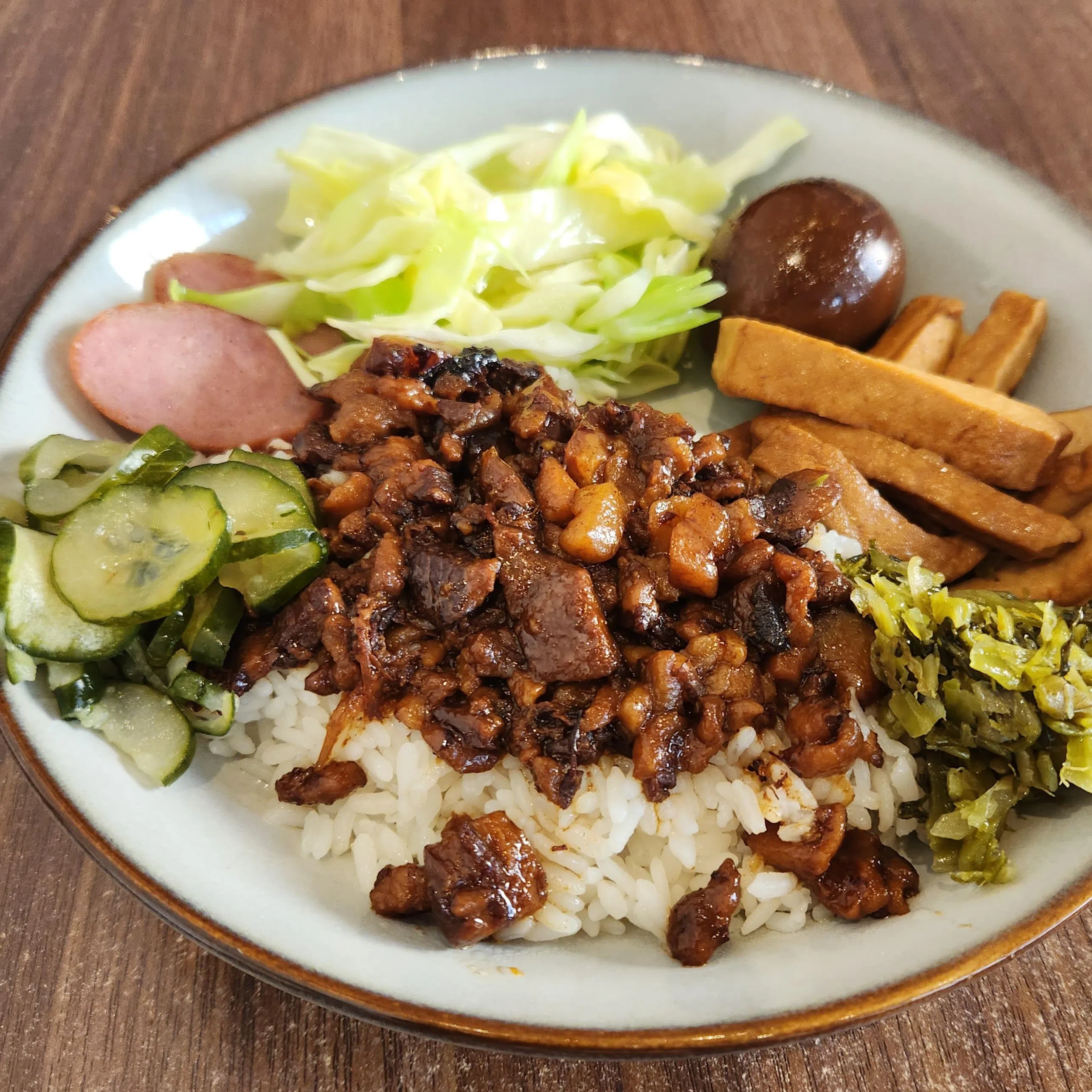 恋恋湾味的卤肉饭肥油比例高，一口吃下咸肥香溢出。（陈爱薇摄）