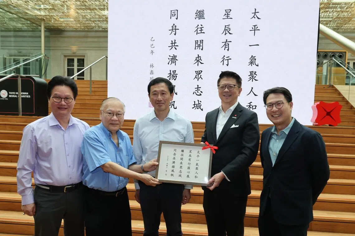 星展银行新加坡区主管林鑫川（右二）特别为这次合作创作一首诗，并在社会政策统筹部长兼卫生部长王乙康（左三）的见证下，把作品赠送给太和观创始主席、现任副主席李锦祥（左二）。太和观副主席许悦明（左一）和太和观首席执行官李德生（右一）也参加仪式。（梁麒麟摄）