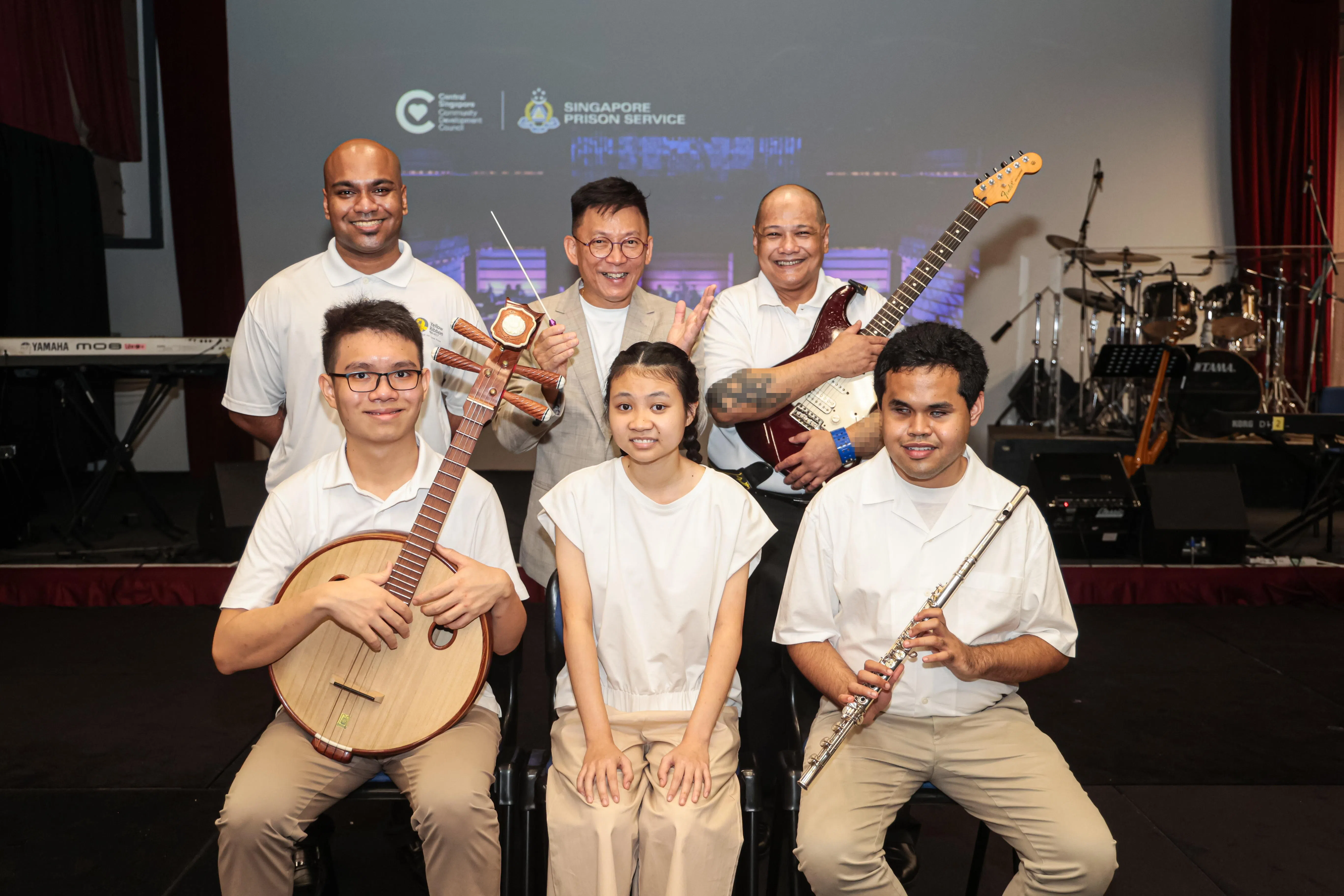 紫色交响乐团与新加坡监狱署表演艺术中心乐队首次合作。前排（左起）：紫色交响乐团的王博毅、罗紫瑄和劳伦斯。后排（左起）：PAC乐队主唱尤雷什、紫色交响乐团指挥郭永德和PAC乐队吉他手法齐。（李冠卫摄）