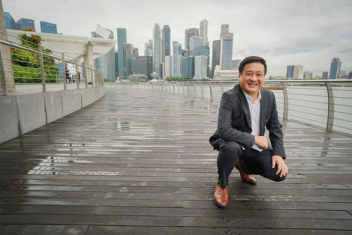 专营木制产品和户外休闲家具的实大控股（Sitra Holdings）准备在新加坡成立知识中心。图为公司执行董事周秋祥在滨海湾金沙步行街拍照，步行街是该公司负责的项目，主要使用来自印度尼西亚且获得森林管理委员会认证的巴劳木（Yellow Balau）。 （特约余维权摄）