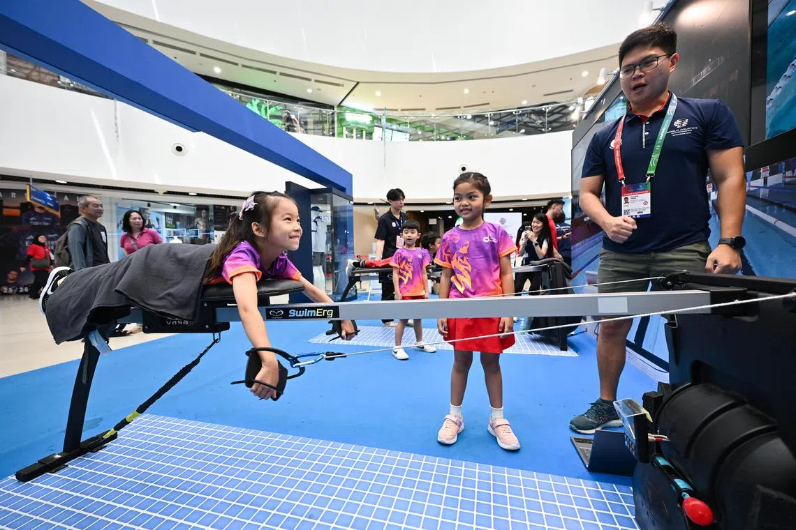 莎拉·赛雅琪尔（中）和她的同学张墨萱（左），挑战了设在嘉龙威购物广场的世锦赛活动设施。（海峡时报）