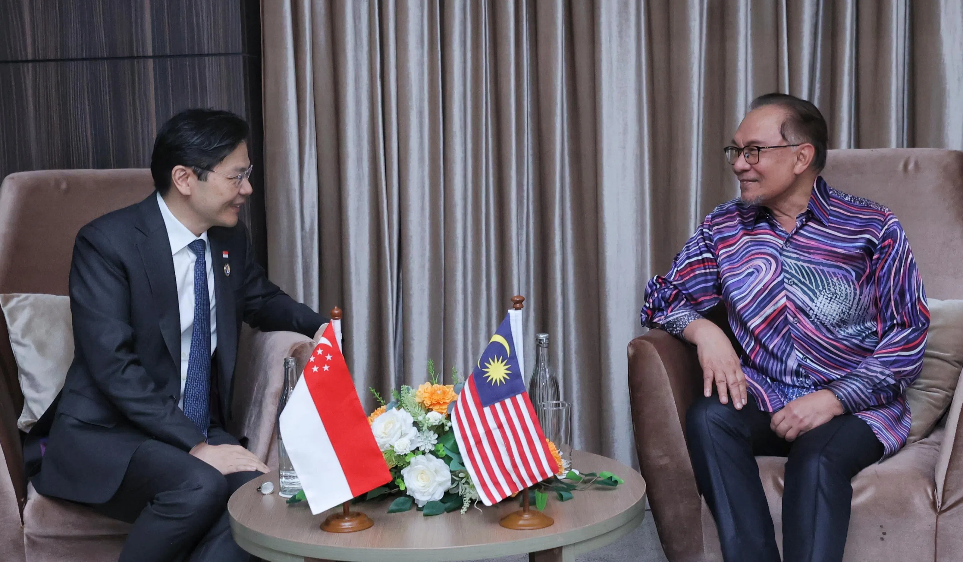 总理兼财政部长黄循财（左）10月9日在老挝万象出席亚细安峰会期间，与马来西亚首相安华（右）会面。（数码发展及新闻部提供）