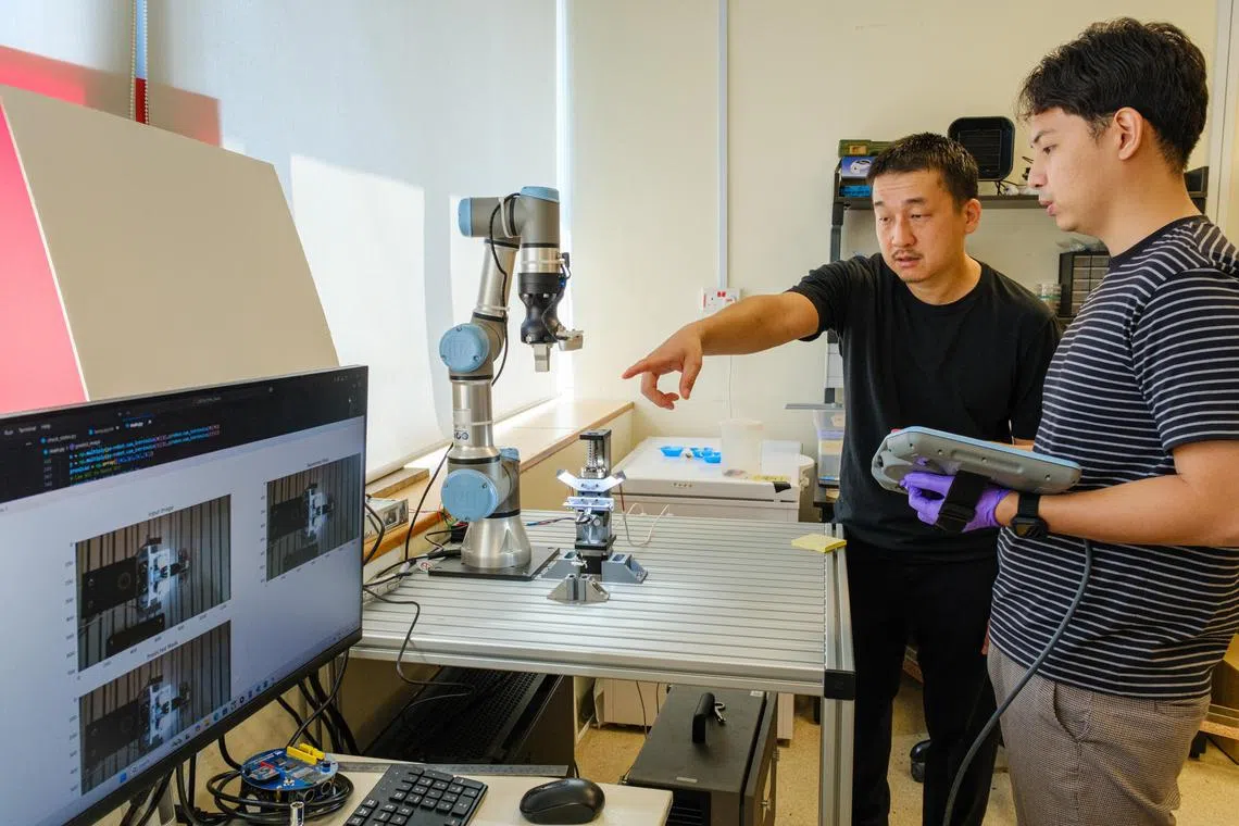 
南洋理工大学佐藤裕崇教授（Hirotaka Sato，左）与科研人员，合作测试自动化半机械昆虫“生产线”原型。系统可在一分钟多一点的时间内，将微型电子背包安装在马达加斯加嘶鸣蟑螂背上，速度比人工快60倍。（南洋理工大学提供）