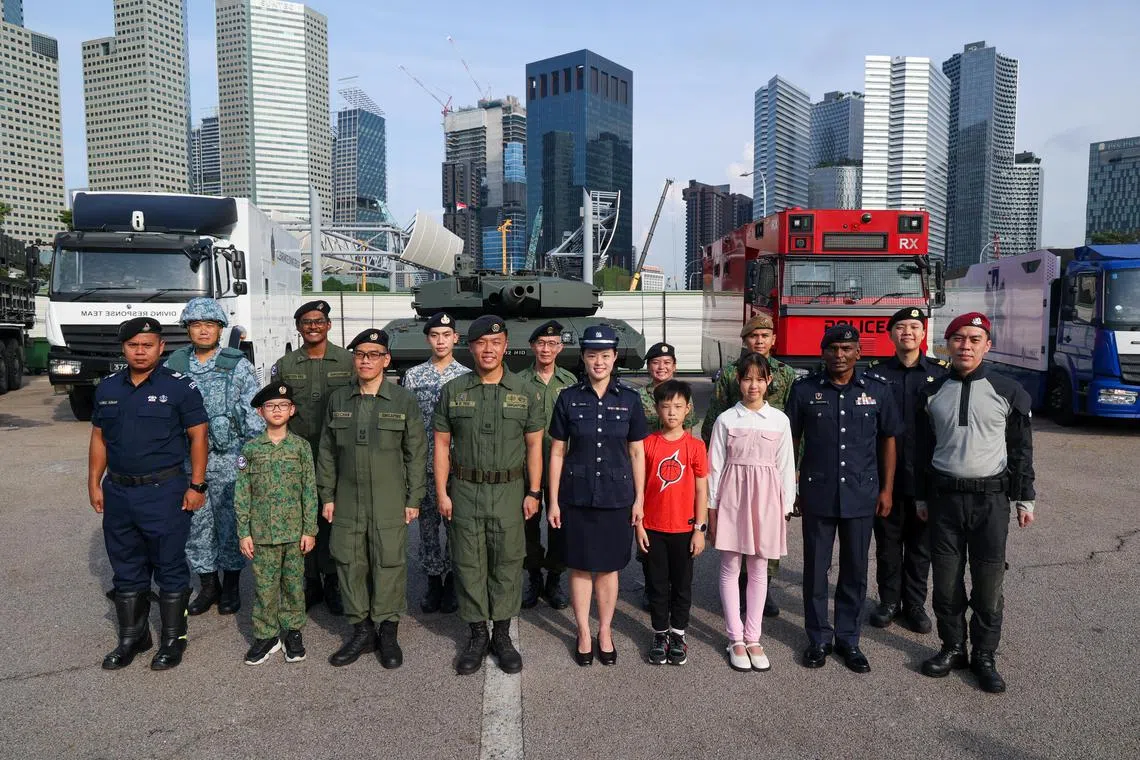 今年的机动部队由新加坡武装部队、内政团队与新加坡海事及港务管理局联合组成，队伍超过800人，出动约170件装备。图为来自武装部队和内政团队的指挥官与家人在军备前合影。（张俊杰摄）