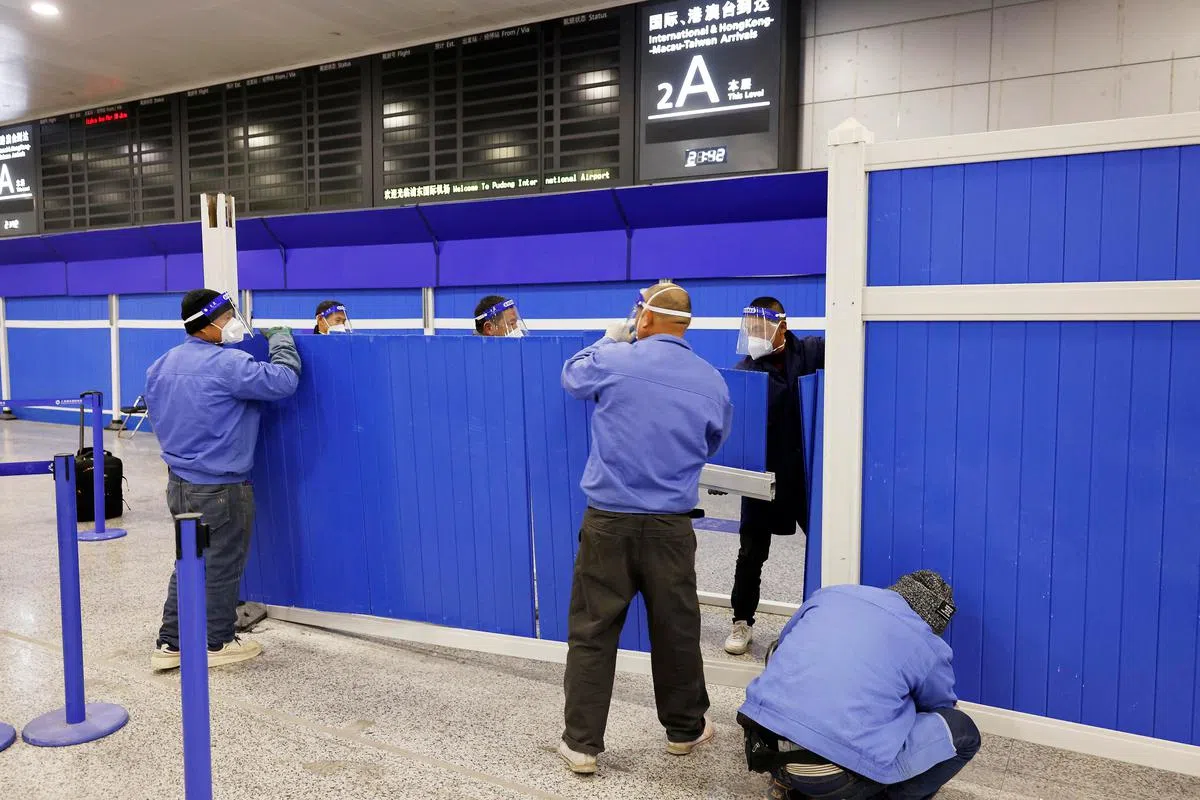 工作人员在中国解除入境全员核酸和集中隔离的前一天（1月7日），拆除上海浦东国际机场国际航班抵境大厅内用来进行隔离的设施。（路透社）