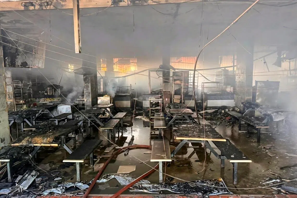 咖啡店的好几个摊位都遭殃，烧得焦黑一片，一片狼藉。 （取自新加坡民防部队脸书）