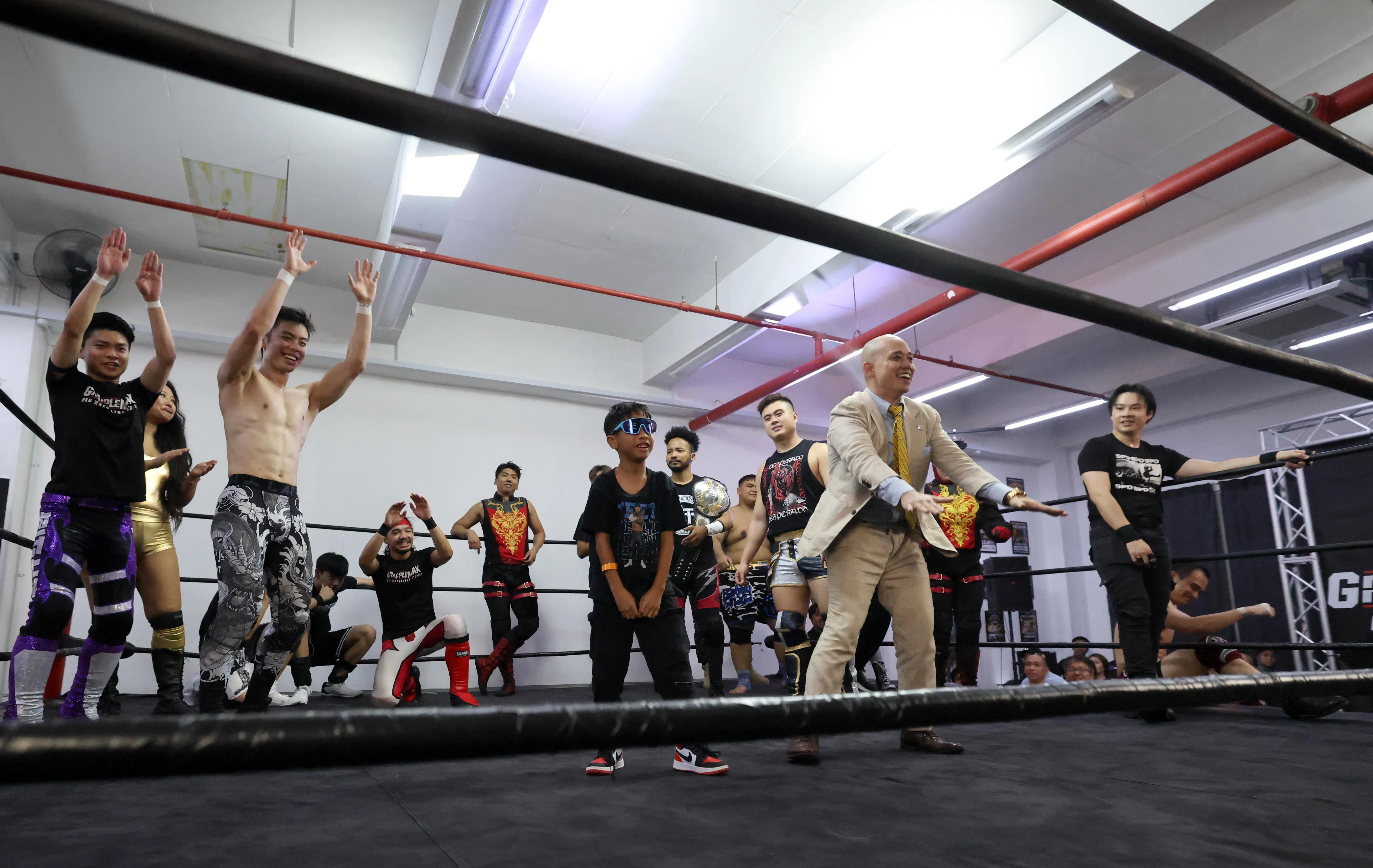 演出结束后，摔跤手与小观众互动，乐翻全场。（梁麒麟摄）