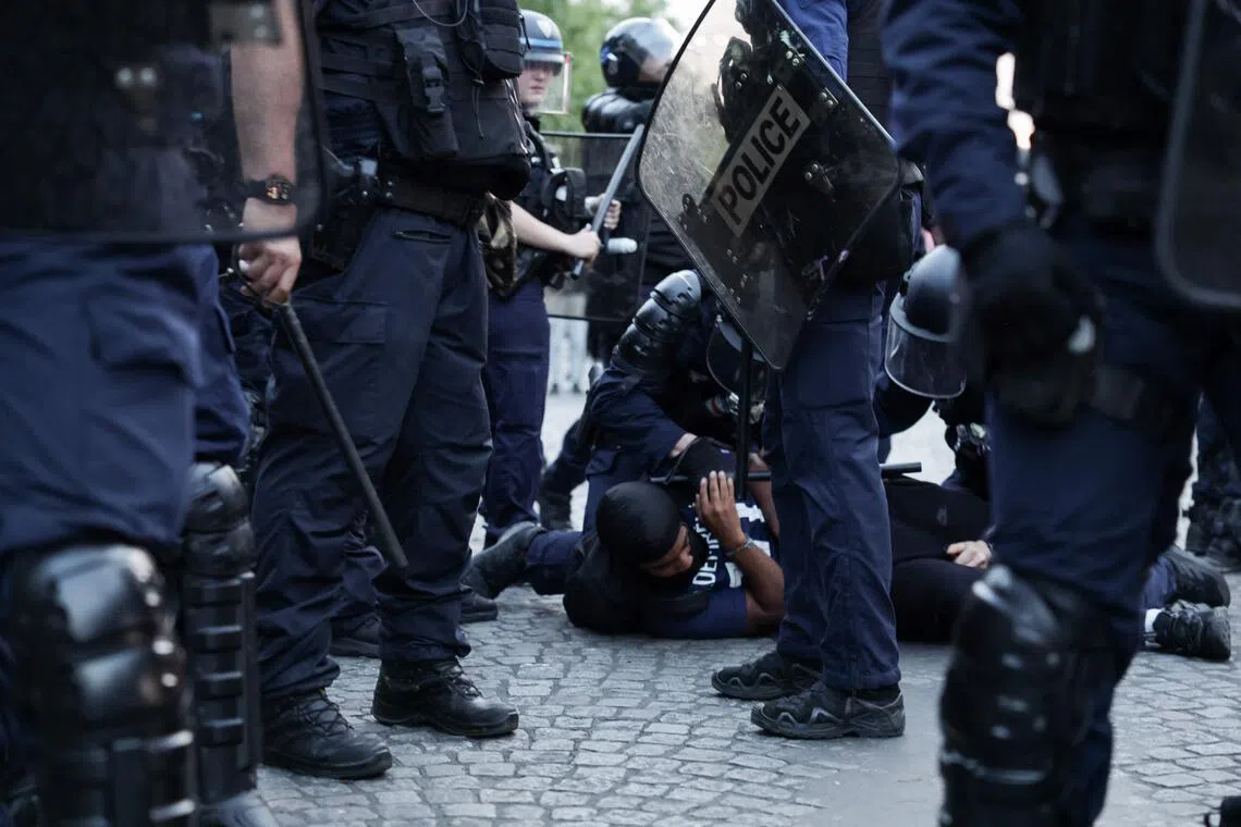 巴黎警方拘捕一名在香榭丽舍大街滋事的巴黎圣日耳曼球迷。（法新社）