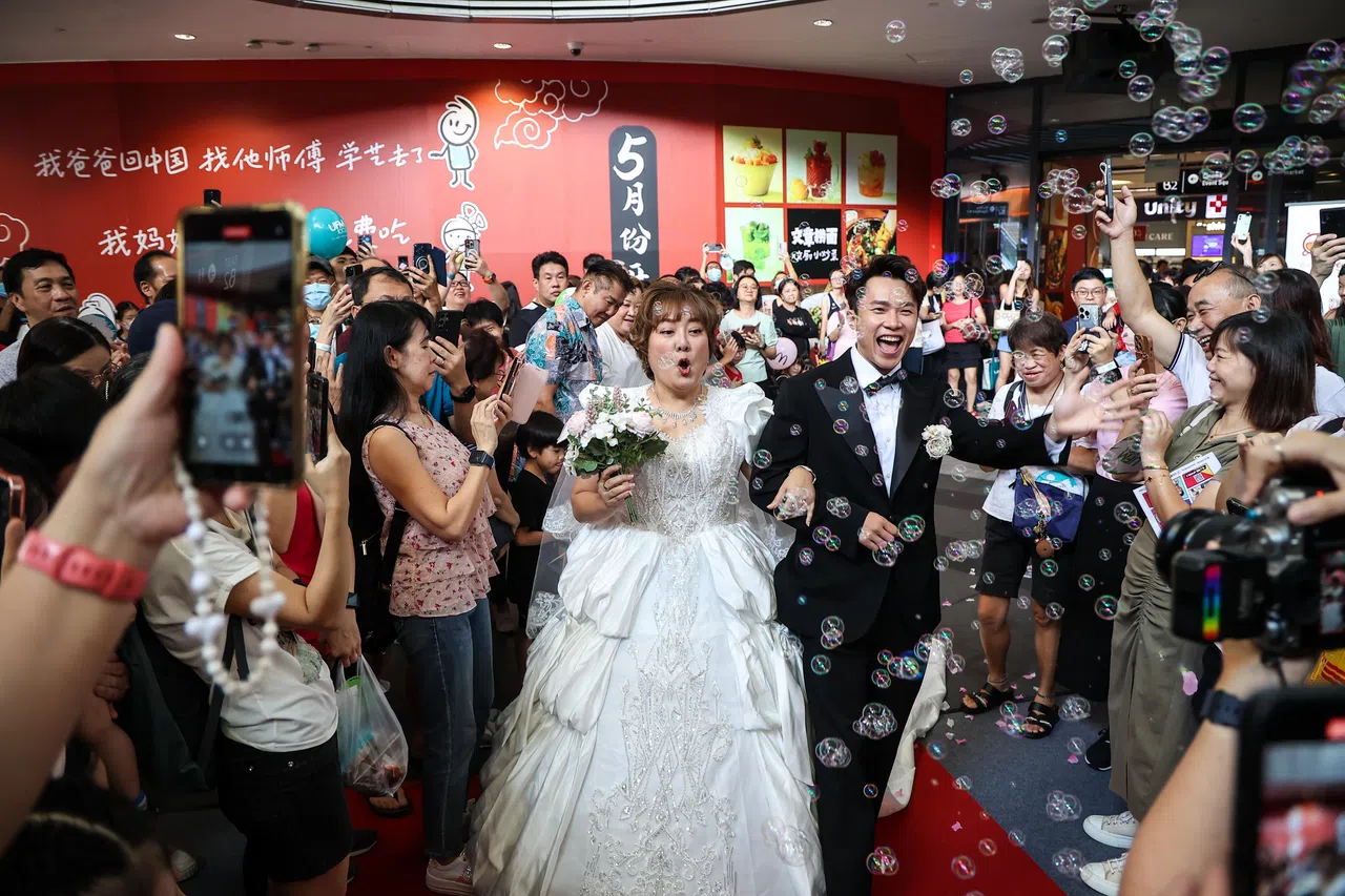 总决赛活动现场，一对“新人”煞有其事地各自穿着西装、拖尾白色婚纱出场。（关俊威摄）
