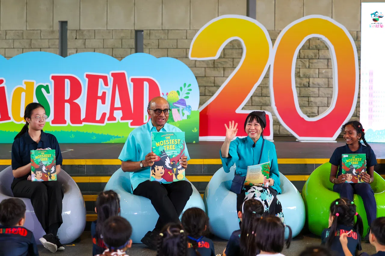 尚达曼总统（左二）与夫人珍一藤木（右二）星期六在活动现场，与两名儿童启蒙阅读计划年轻“校友”周一心（左一）和鲁达比娅，为在场儿童说故事。（林明顺摄）