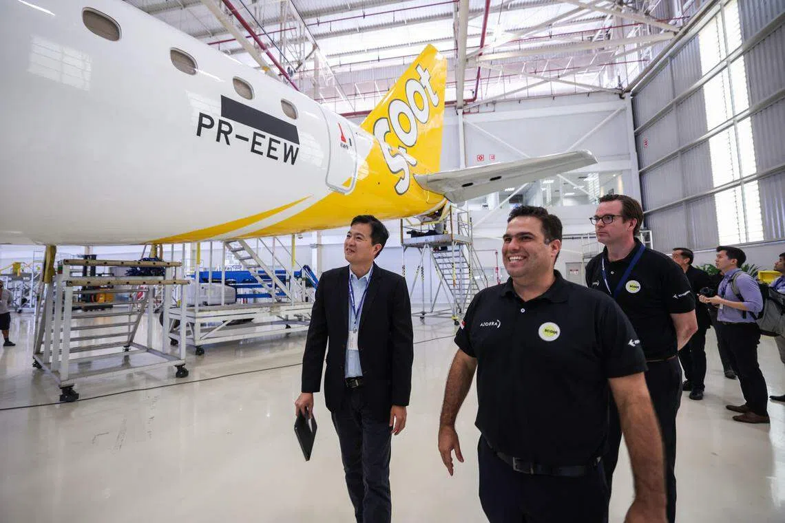 酷航首席执行官汤康庄（左一）在巴西航空工业公司（Embraer）于巴西圣若泽杜斯坎普斯（Sao Jose dos Campos）的停机库，检查将接收的第一架E190-E2型客机。（白艳琳摄）