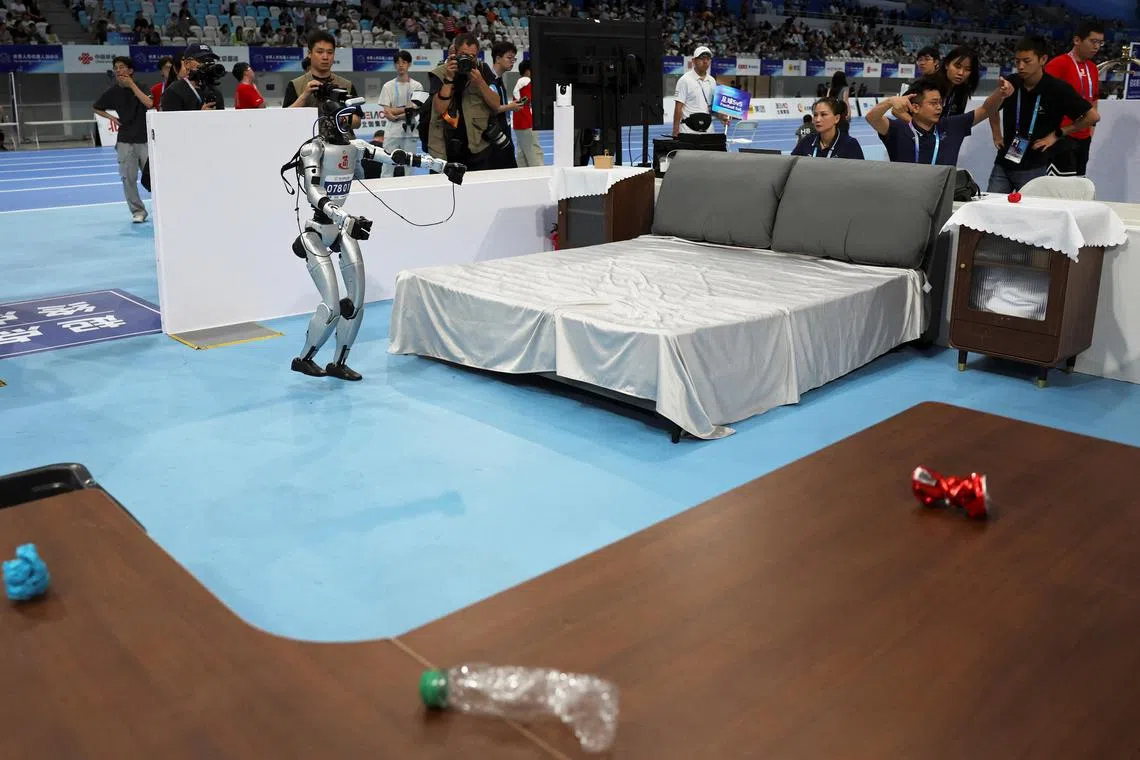 机器人星期六（8月16日）在运动会上参加酒店场景中的清洁服务比赛。（路透社）