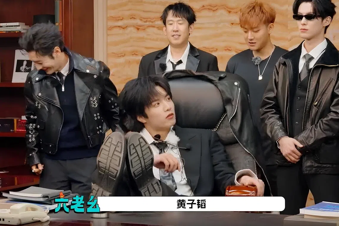 时代少年团刘耀文（前）在老板李飞的办公室桌翘脚，大胆扮演公司总裁。黄晓明（后排左起）、于洋、黄子韬和王鹤棣配合扮演他的员工。（节目截图）