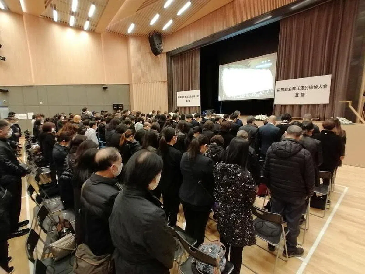 香港市民12月6日上午在北角社区会堂观看江泽民追悼大会直播，并默哀悼念。（香港中通社）