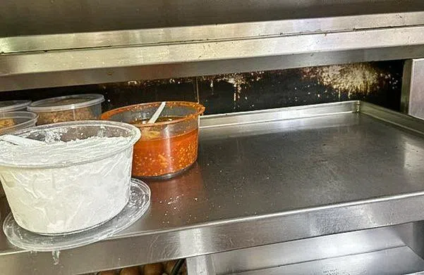 山乐坊Ayam Penyet President餐馆门店的食品架和墙砖，未达到食品安全标准。（新加坡食品局提供）