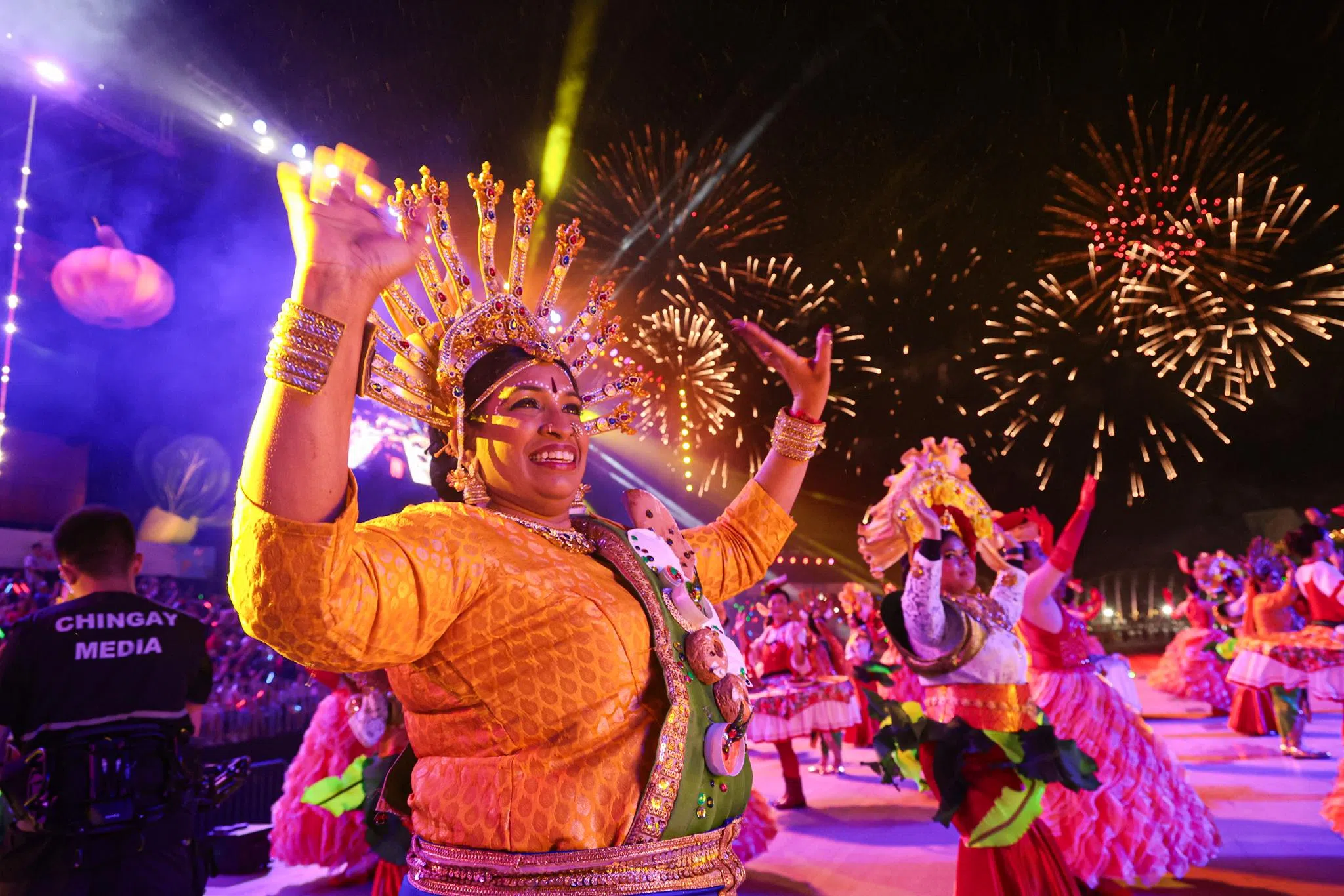 舞者在灿烂的烟花光芒下翩翩起舞，伴随着激昂的音乐，把现场气氛推向高潮。（李冠卫摄）