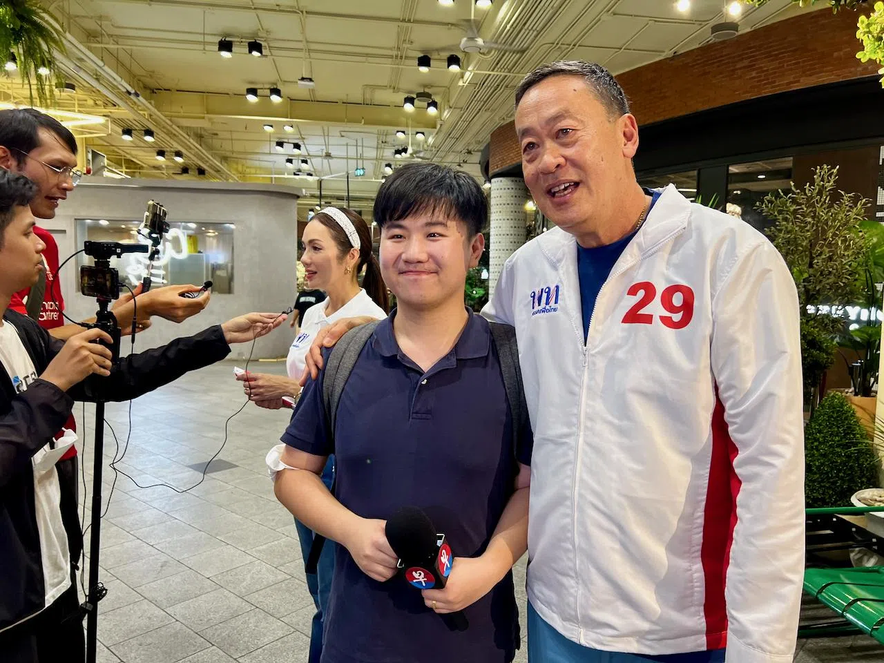 为泰党首相候选人社德他（右）与《联合早报》视频记者邴泓剑与合影。（吴汉钧摄）