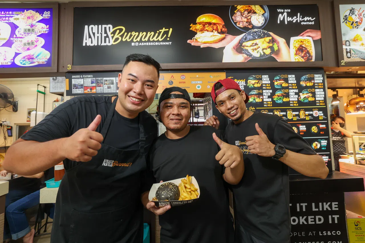 Ashes Burnnit汉堡店创始人李萨菲克（左一）与团队一同经营着七家设在小贩中心的汉堡档口。（蔡家增摄）