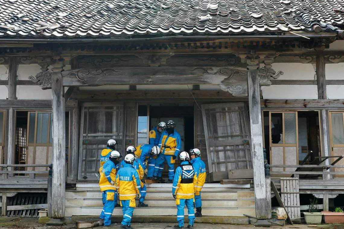 在石川县轮岛市，警员星期四挨家挨户检查，以确定房屋里无人受困。（路透社）