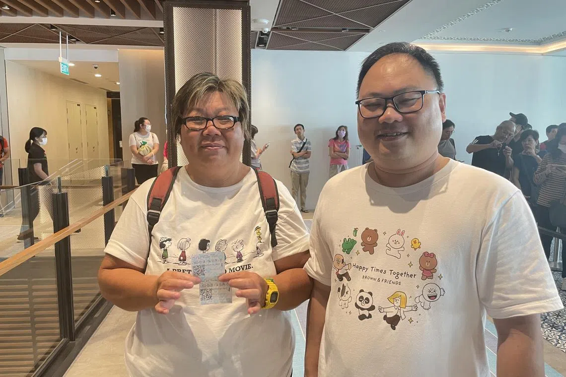 潘美玲（左）与丈夫排了近两小时，成功领取戏票。（李高乐摄）