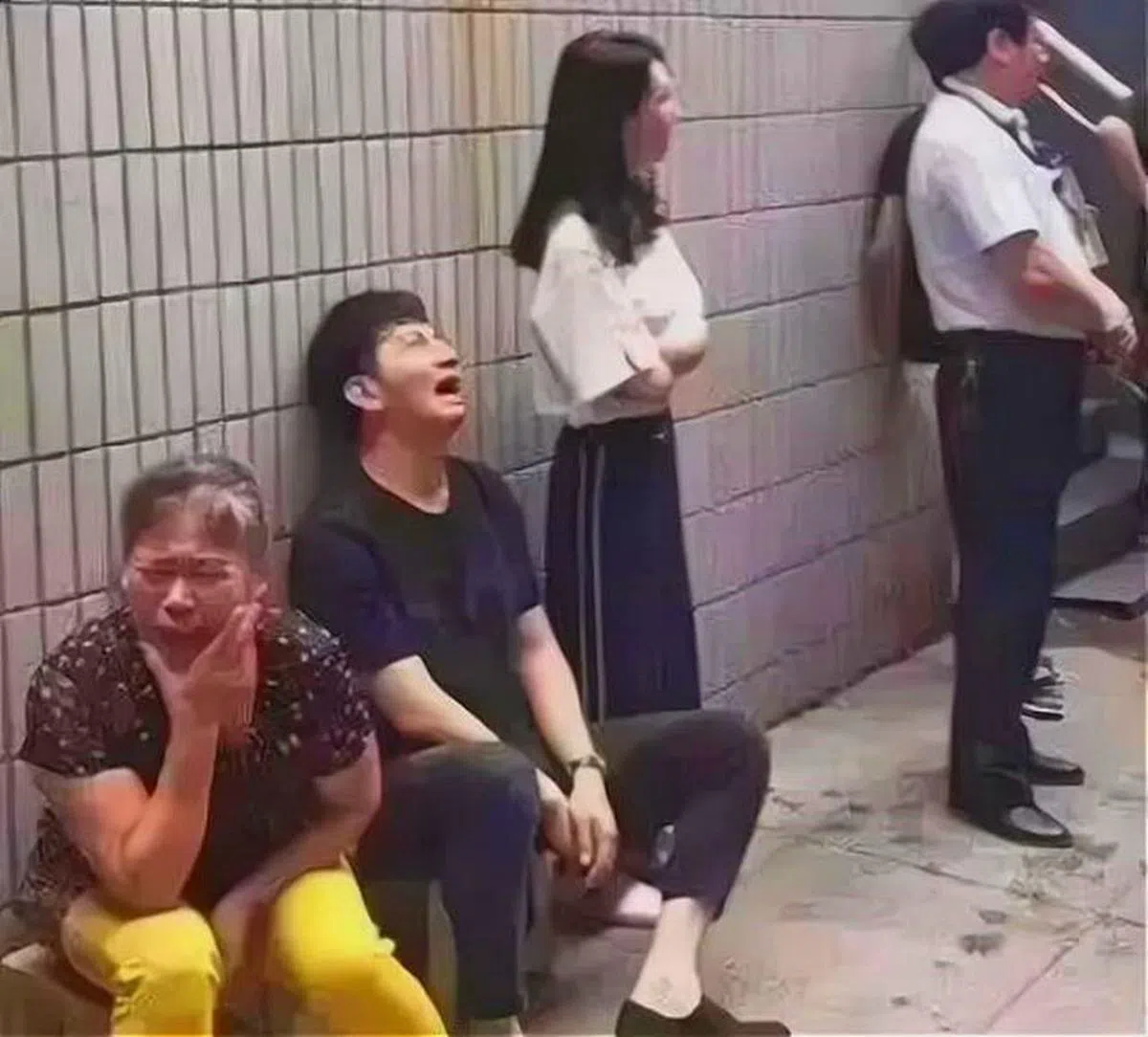 林生斌（左二）在纵火案发生后，被记者拍到他坐在墙角哭泣的画面，感动了无数人。（互联网）