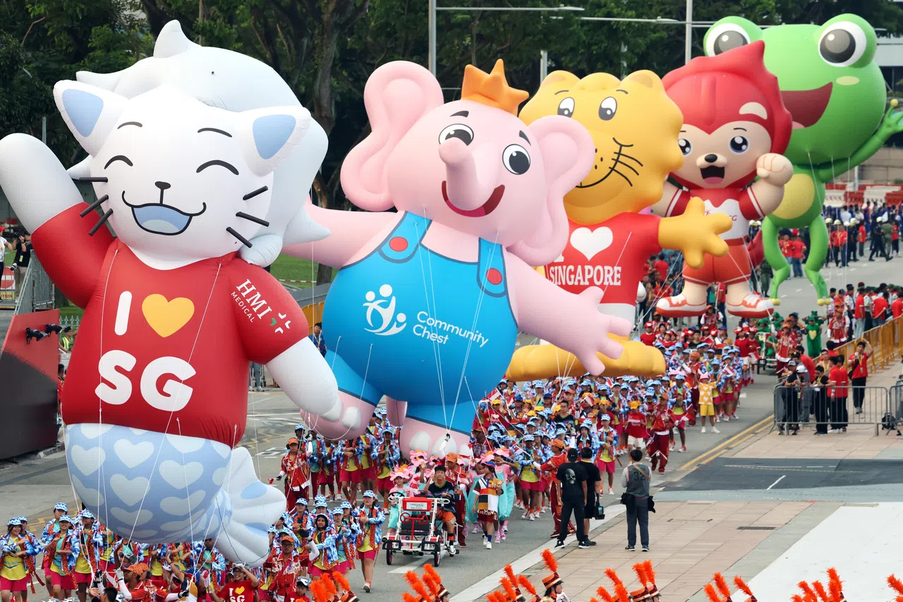 今年的庆典迎来六个吉祥物。鱼尾狮造型的国庆庆典吉祥物“8月”（August）首先出场，接着出场的是公益亲善大使“爱心小象”Sharity、礼貌大使“新雅”（Singa）、推广核心家庭价值观的“贝奇小兔”（Becky Bunny）、推广体育活动的“尼拉”（Nila），以及环保大使“绿色队长”（Captain Green）。（邝启聪摄）