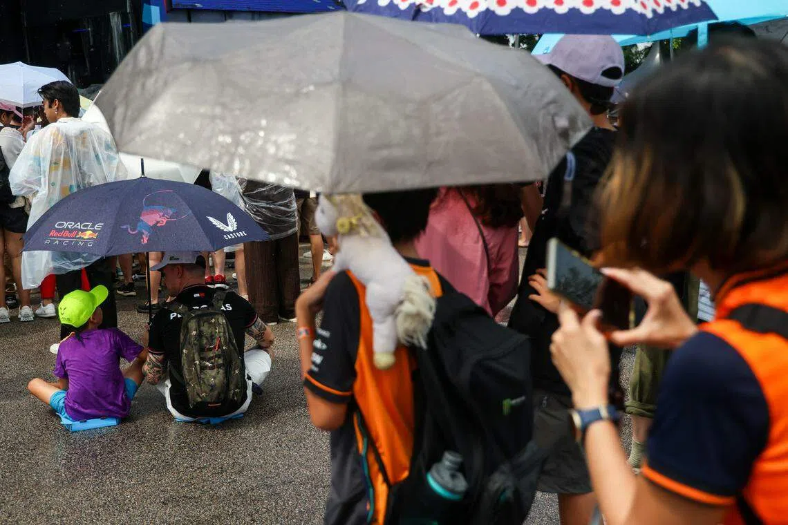 车手见面会开始前雨势不断，不少民众撑伞等待。（关俊威摄）