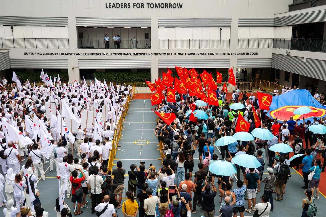人民行动党（图左）与工人党（图右）支持者星期三（4月23日）不畏下雨天，来带尤索夫依萨中学支持各政党候选人。（林明顺摄）
