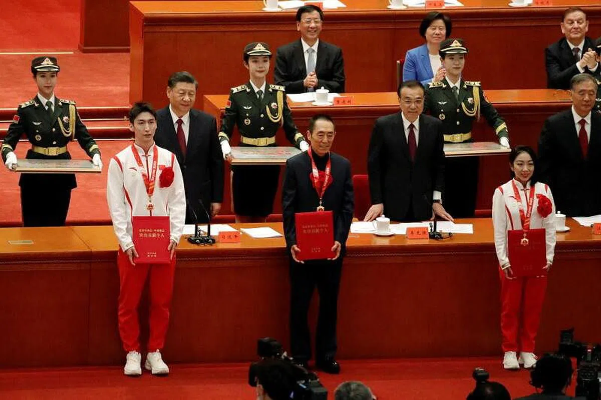 张艺谋还执导了北京2008年奥运会开闭幕式，今年2月召开的北京冬奥会开闭幕式也是由他担任总导演。图为张艺谋（前排中）和其他运动员在北京2022年冬奥会表彰大会上。（路透社）