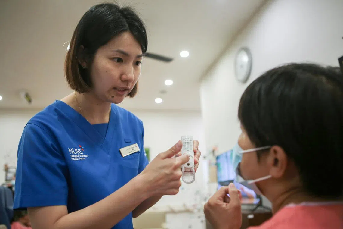 亚历山大医院助理临床护士戴癸冰（左）向病患解释如何使用更环保的干粉吸入器。（刘志诚摄）