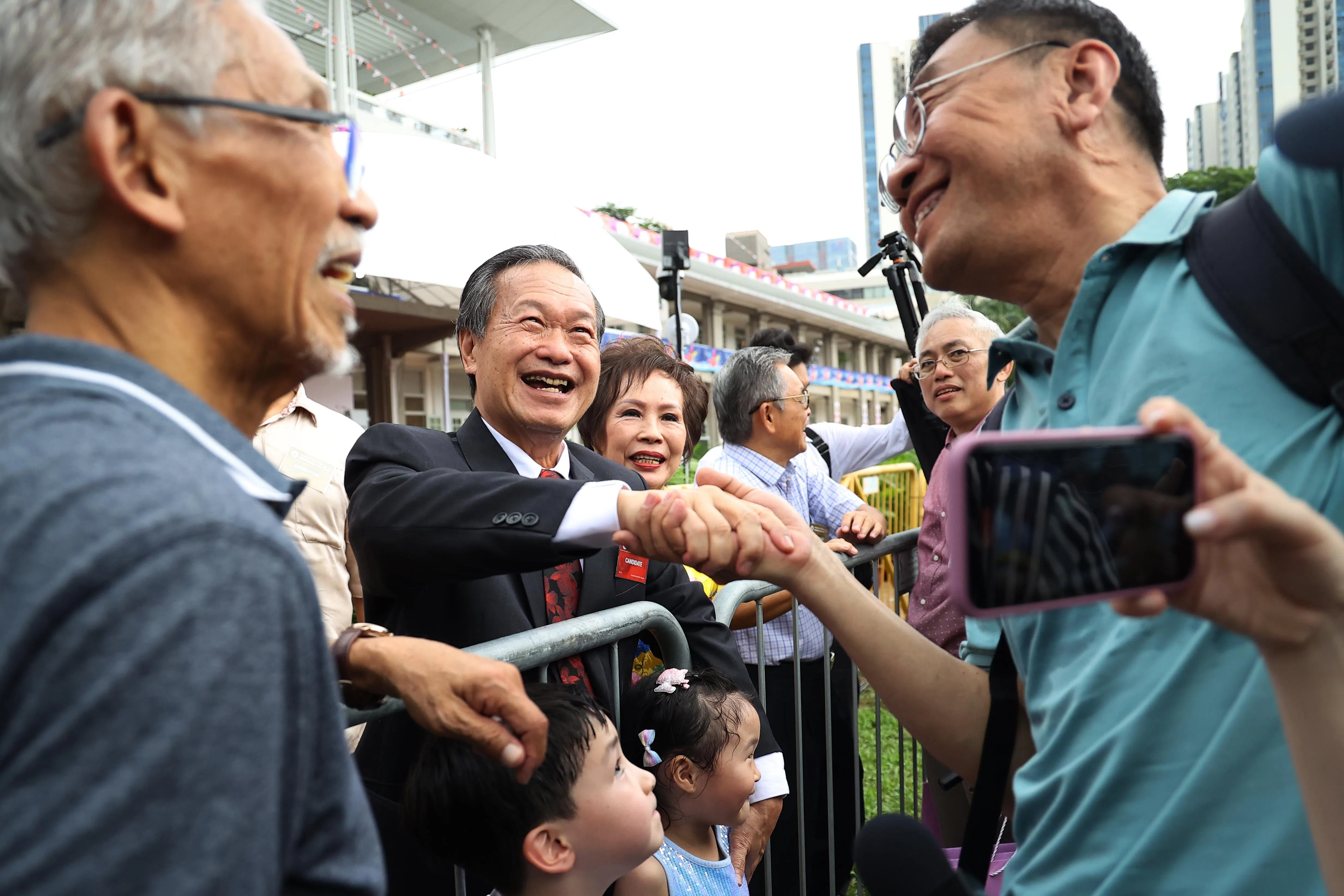 陈钦亮（左二）和夫人郑㛢𤪧离开人民协会总部提名中心前，有数十名支持者涌上前和他握手，并不断地喊着他的名字。右二是反对党人民力量党秘书长吴明盛。（林明顺摄）