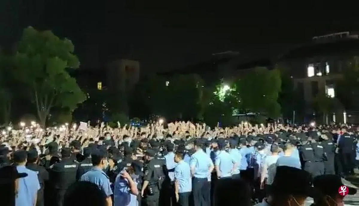 在江苏省南京师范大学中北学院，有大批警员到校与学生对峙，学生点起手机灯形成灯海。（视频截图）