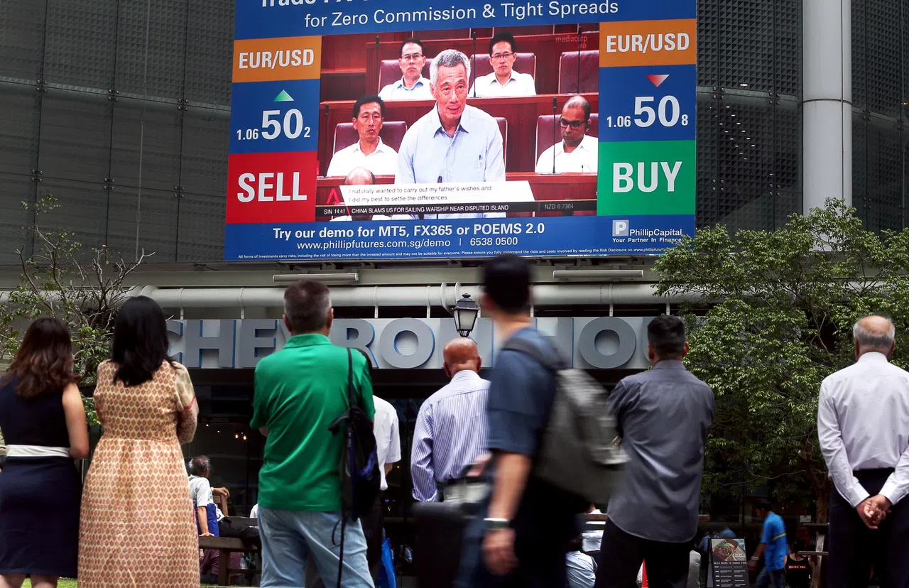 建国总理李光耀故居争端受到举国瞩目。2017年7月3日，不少公众在莱佛士坊地铁站外的大荧幕前，驻足观看李总理就这起争端发表声明的新闻报道。（档案照片）