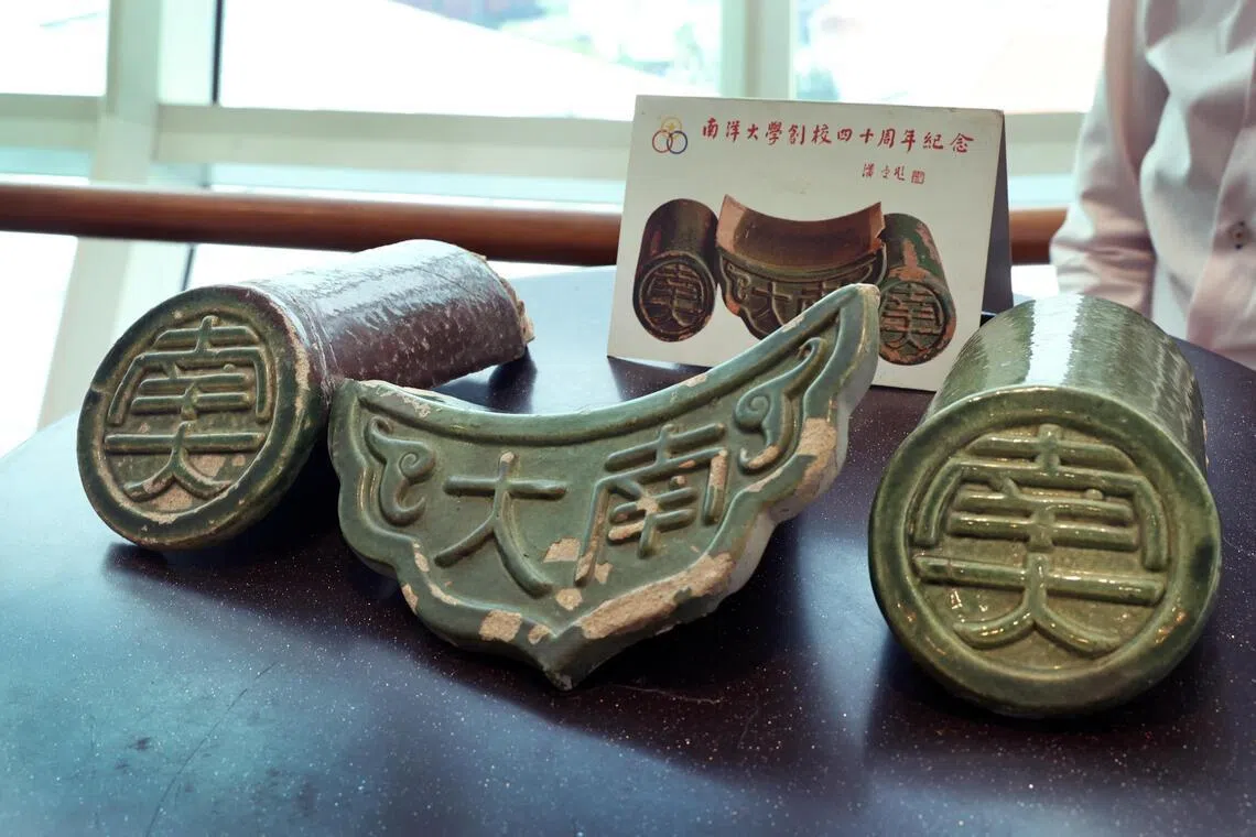 石叻坡民俗文化馆馆长陈来华带一批收藏文物到现场，包括一套上世纪70年代的明信片与南大周边，为历史再添实物见证。（周国威摄）