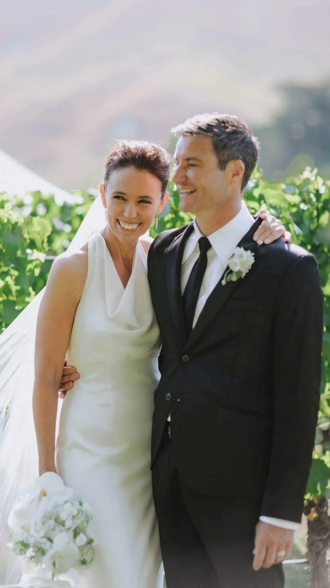 新西兰前总理阿德恩在订婚近五年后总算举行了婚礼，她身穿挂脖婚纱，多年伴侣盖福德则穿着黑色西装。 （法新社）