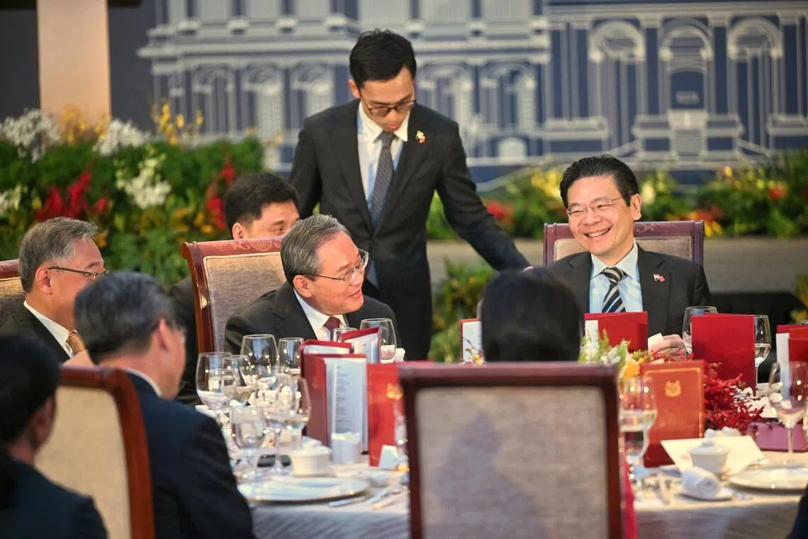 黄循财总理（右一）与中国总理李强在晚宴上交谈。（海峡时报）