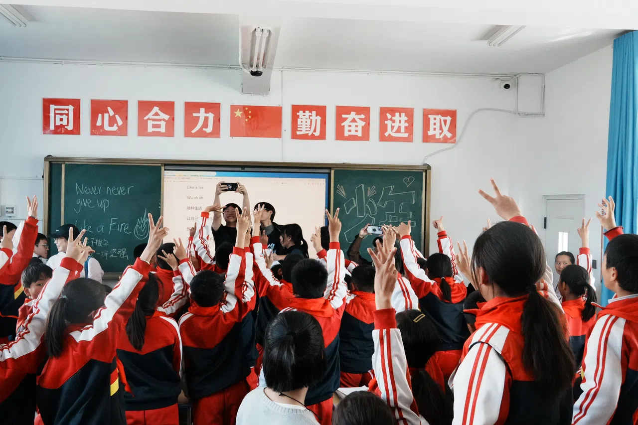 小老师和孩子们打成一片后，来张群拍留念。（华侨中学高中部江奕莹摄）