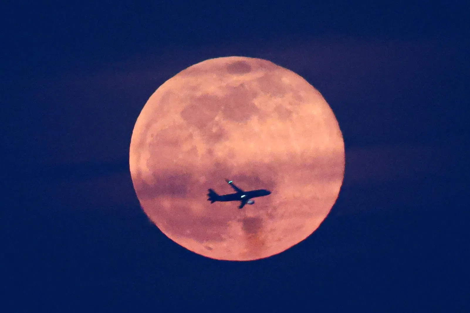 飞机在丰收月下升起，载着满客机的游子飞向他们的梦。（李冠卫摄）