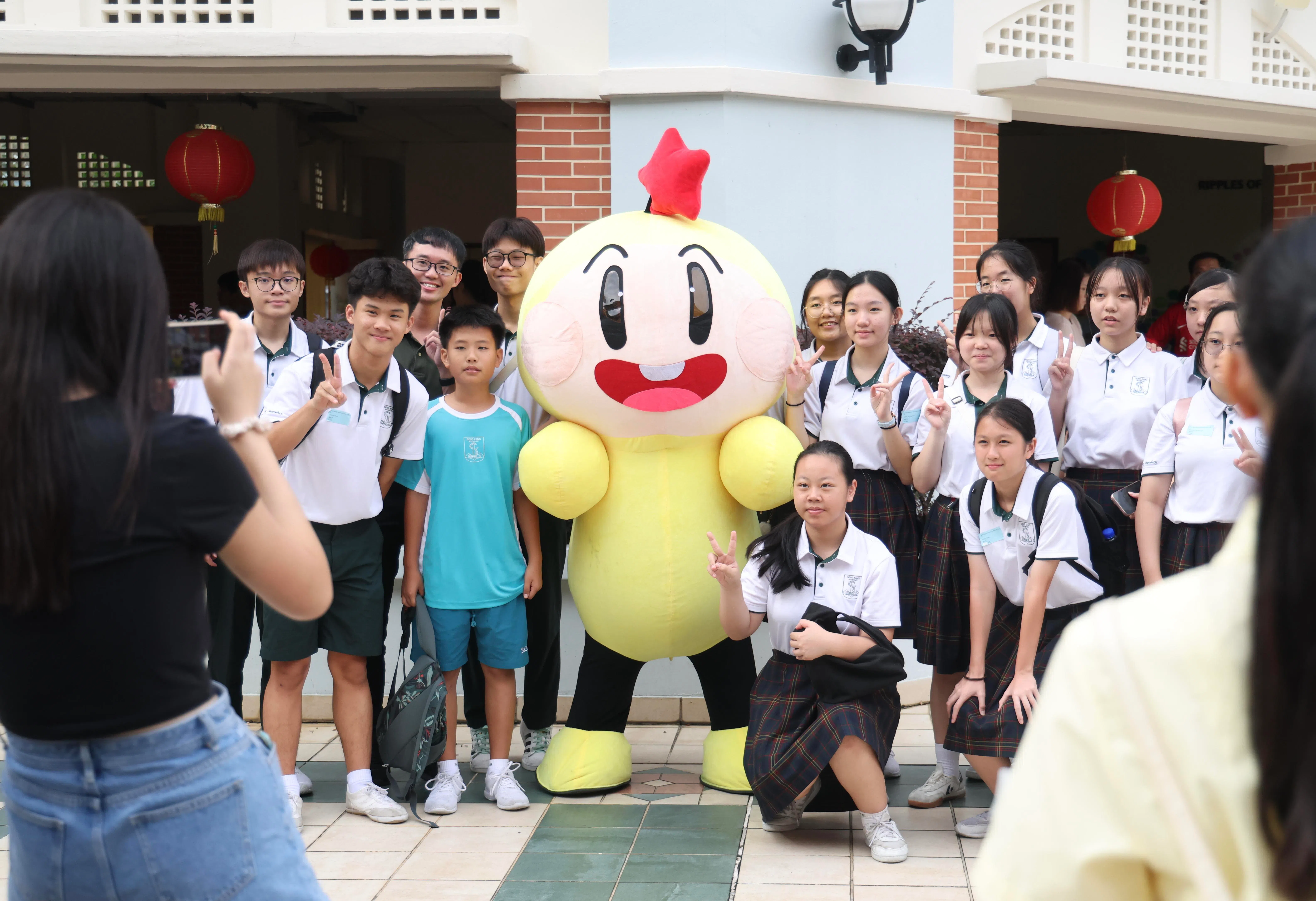 今年华文大比拼初赛于3月7日举行，比赛结束后，同学们和大拇指吉祥物合照留念。（郑一鸣摄）