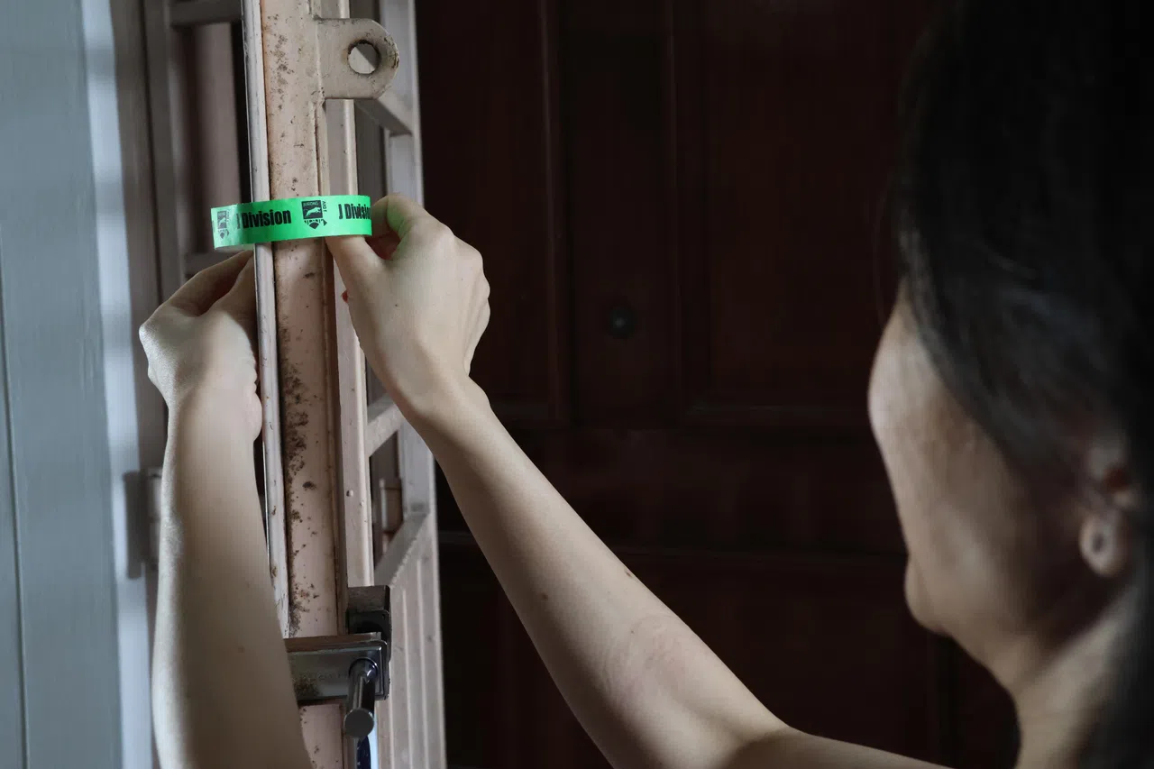 须疏散的居民在离家后会把警方分发的绿色粘条粘在门上，以示家人已全数离开。（梁麒麟摄）