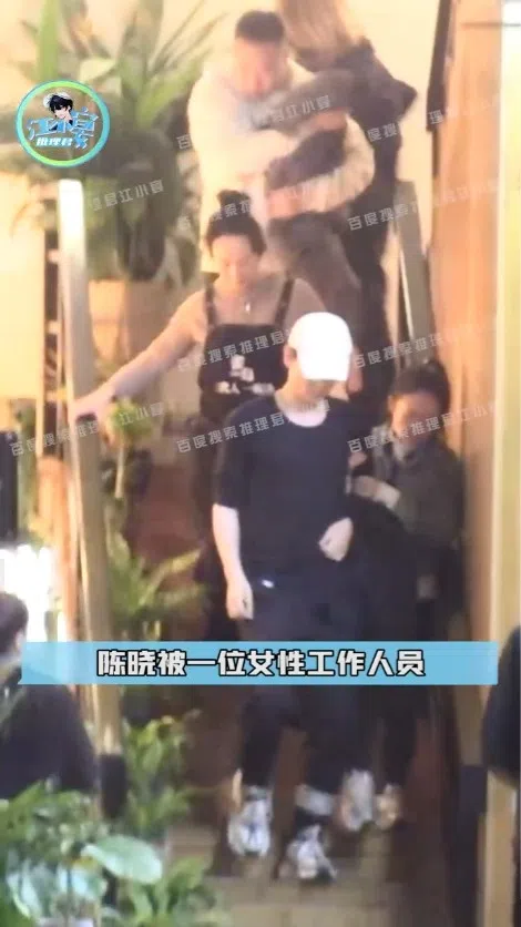 陈晓（前排左）由一名女性工作人员扶着，被指看起来像是喝醉的样子。（视频截图）