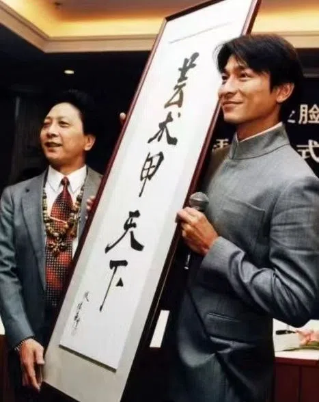 刘德华（右）送彭登怀一幅写着“艺术甲天下”的字画。（互联网）