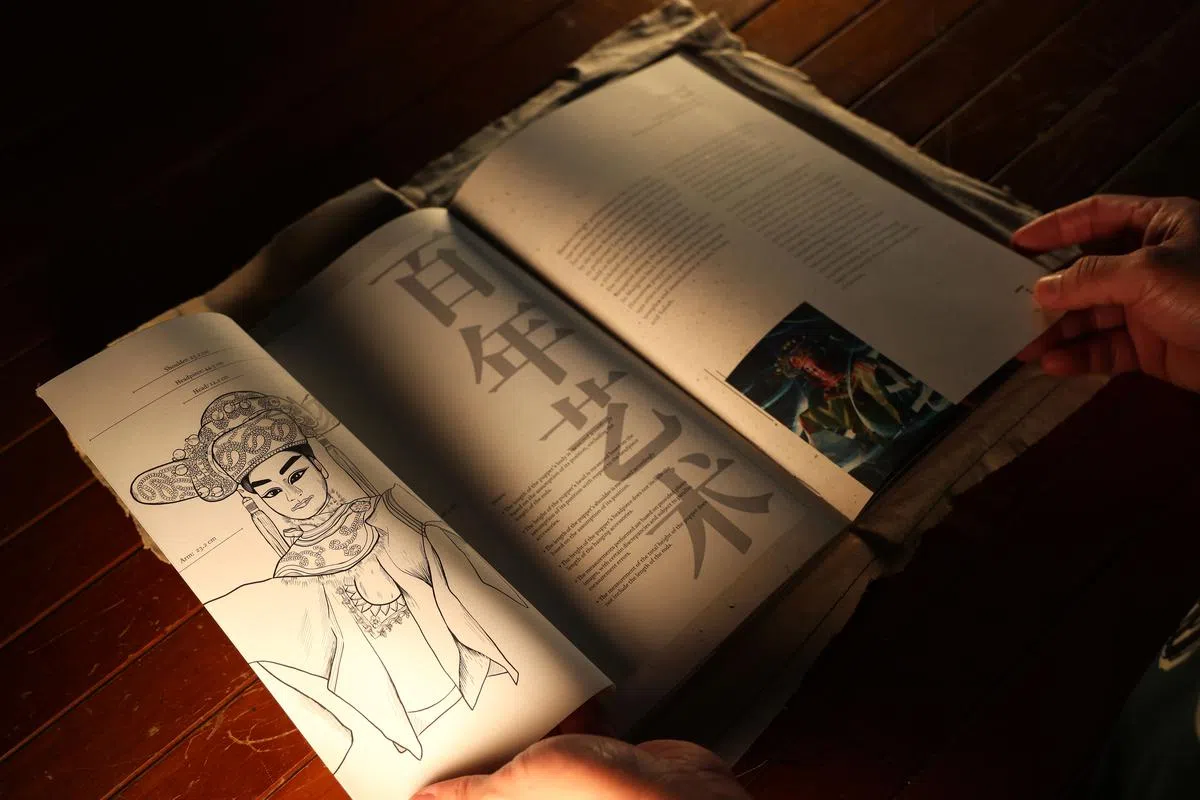 《淡》装帧设计富层次感，细节丰富，重现本地木偶戏后台乱中有序的活力和生气。（叶振忠摄影）