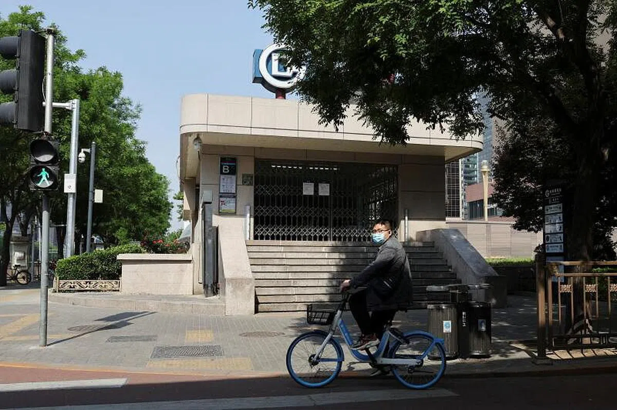 一名北京市民昨天骑车经过被封闭的地铁站。（路透社）