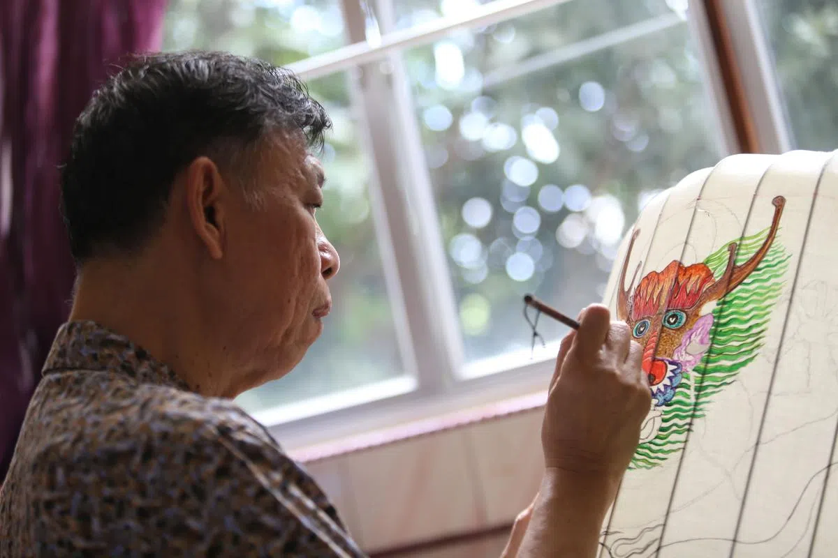 黄沛发自学成才，利用以前学习的工业绘画技巧和对美术作品的喜爱，为福建灯笼作画上色。（摄影/叶振忠）