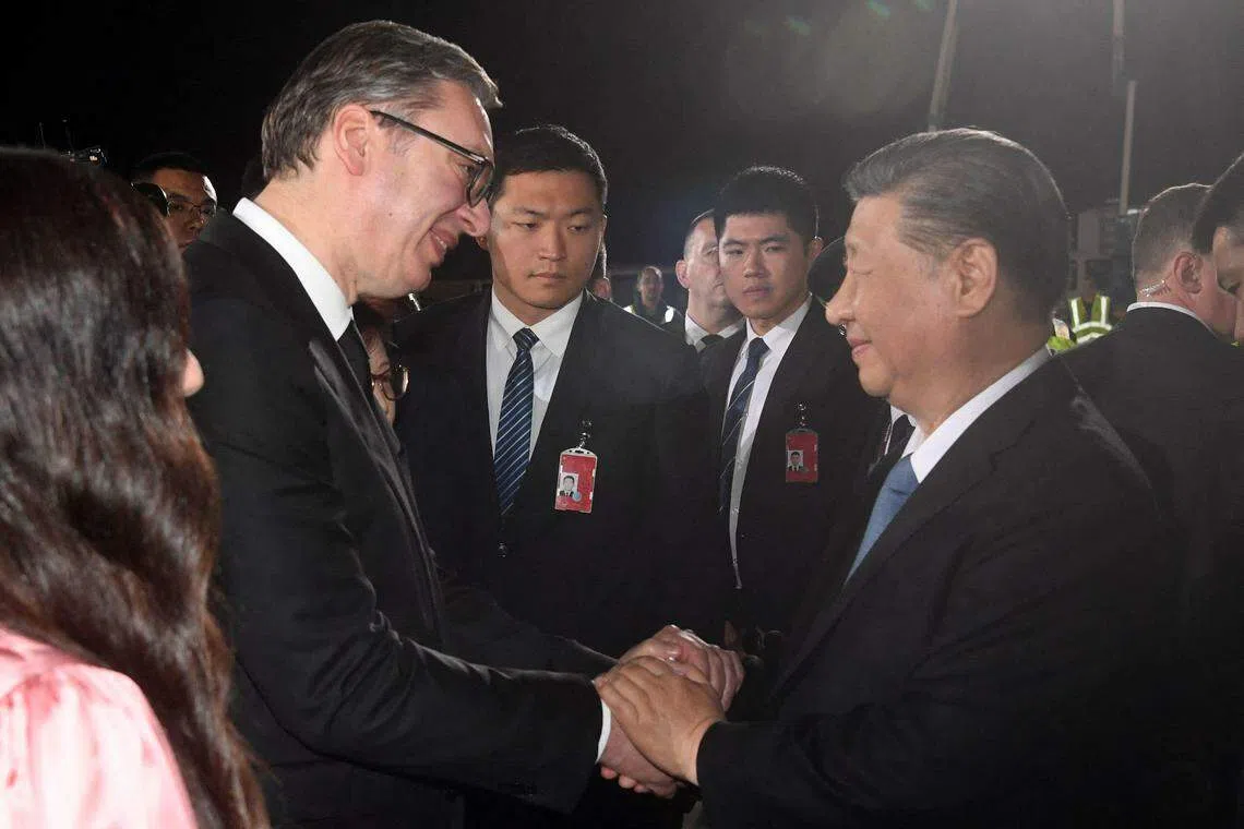 塞尔维亚总统武契奇（左二）星期二晚在尼古拉·特斯拉国际机场迎接到访的中国国家主席习近平，两人在会面时握手示意。（法新社）