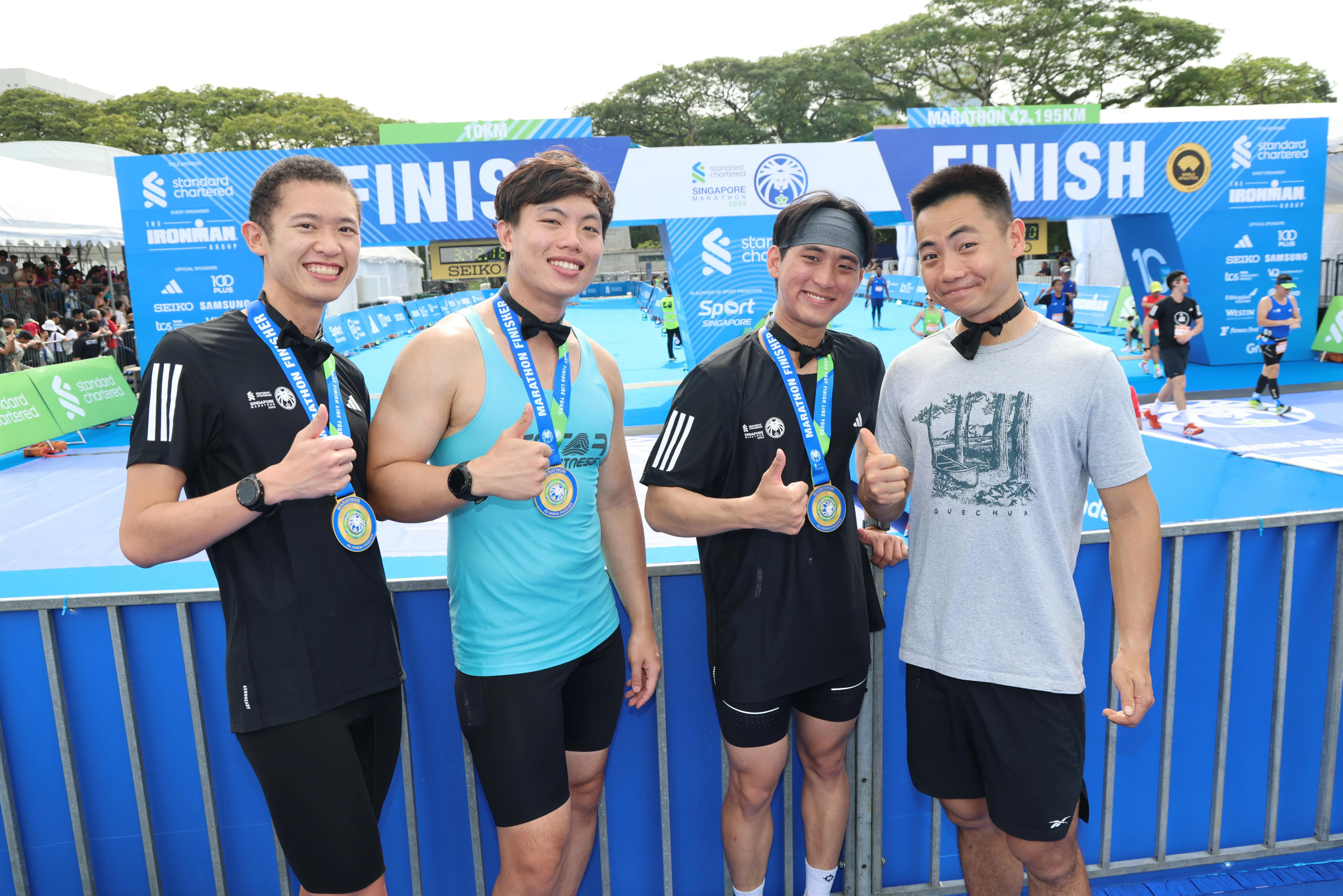 倪昇（左一）、廖斌威（右二）、邓敬源（右一）是骆家轩（左二）的多年好友，也是他婚礼的伴郎，还陪伴他参加了本届马拉松赛事。（梁麒麟摄）