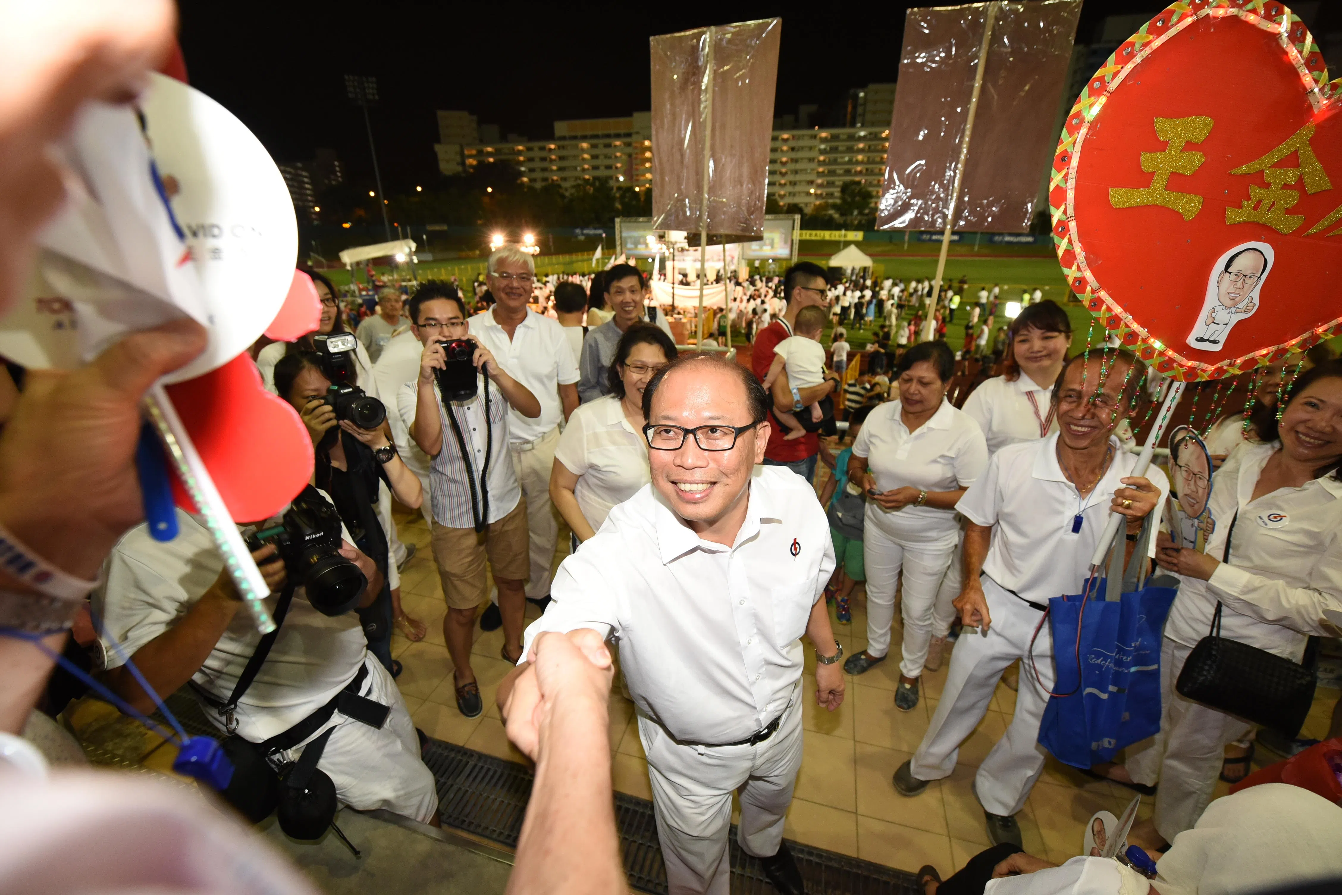 2015年大选成绩揭晓，首次独挑大梁的人民行动党代表王金发（前），在爆发三角战的武吉巴督区中，成功当选。他胜选后在现场与支持者握手致谢。（档案照片）