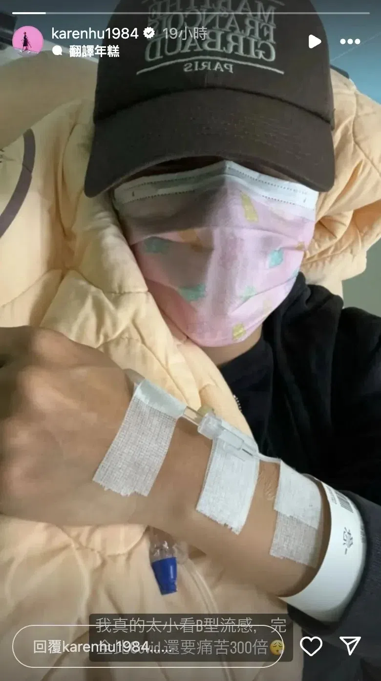 小祯戴帽子和口罩，难受地抱住医院病床的棉被，手上还打着点滴，贴了好几个纱布。（互联网）